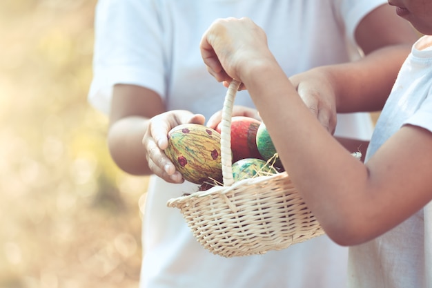 Deux filles d&#39;enfants asiatiques jouant et collectionnant des oeufs de Pâques colorés