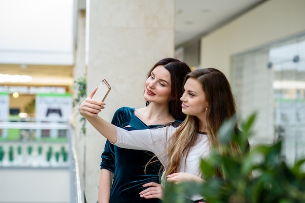 Deux filles faisant du selfi en magasin.