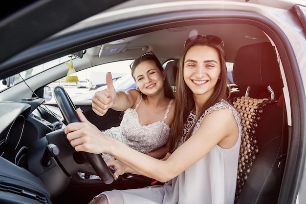 Deux filles heureuses souriant et voyageant en voiture