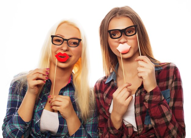 Deux filles hipster sexy et élégantes meilleures amies prêtes pour la fête, sur fond blanc