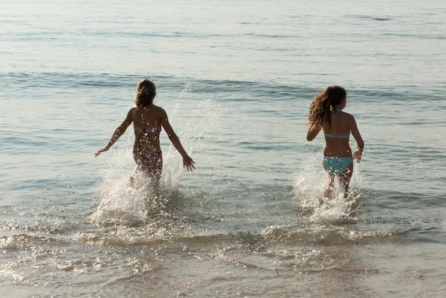 Deux filles meilleures amies s'amusant et éclaboussant de l'eau