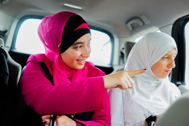 deux filles musulmanes heureux dans une voiture en voyage