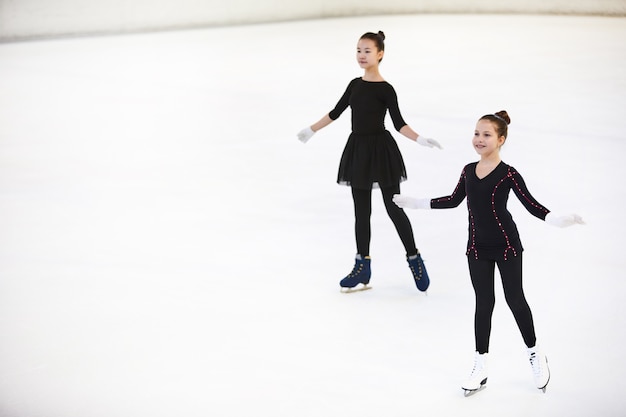 Deux filles posant sur une patinoire