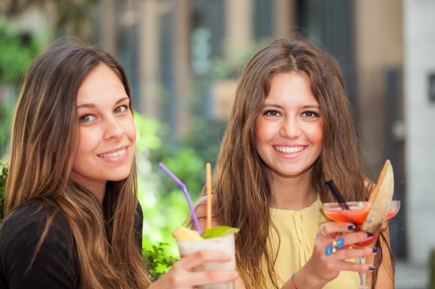 Deux filles prenant un apéritif en plein air