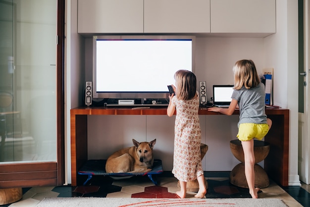 Deux filles regardent la télévision et l'ordinateur de trop près