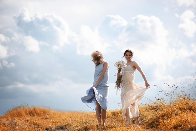 Deux filles en robes dans le champ d'automne