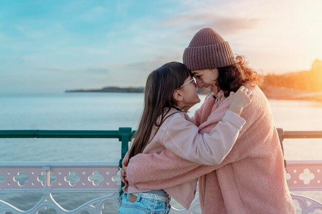 Deux filles s'amusant sur la plage au coucher du soleil