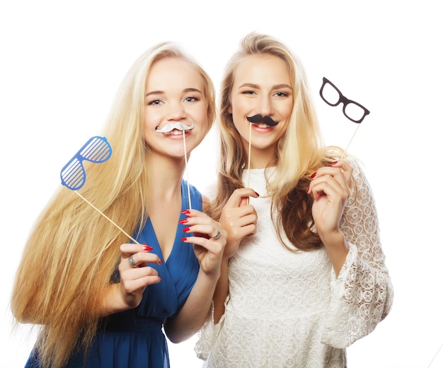 Deux filles sexy élégantes meilleures amies prêtes pour la fête sur fond blanc