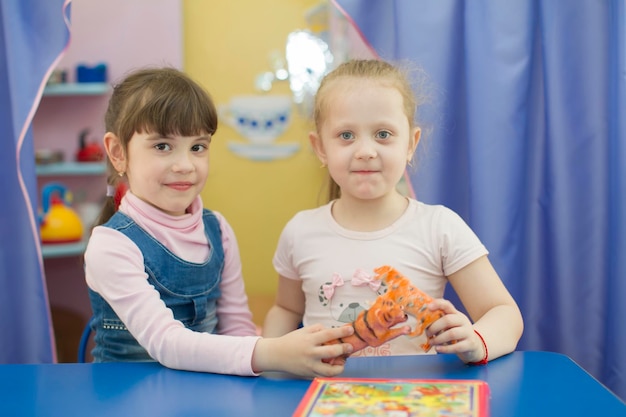 Deux filles de six ans avec un jouet Copines à la maternelle