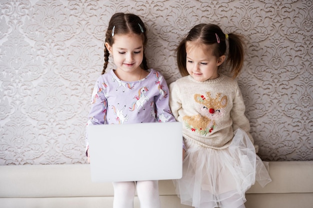 Deux filles sœurs regardant sur ordinateur portable Technologie et concept de maison