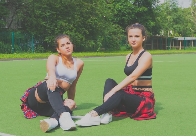 Deux filles sportives posant sur le terrain de jeu.