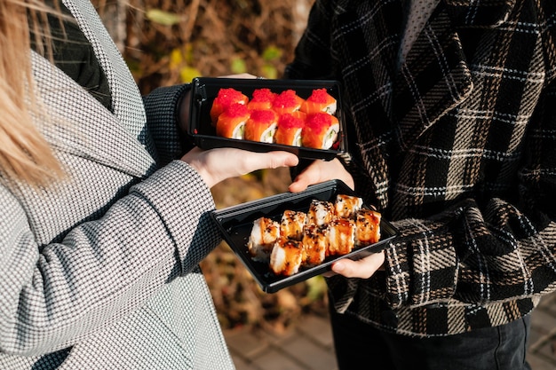 Photo deux filles tenant une boîte de sushi à emporter