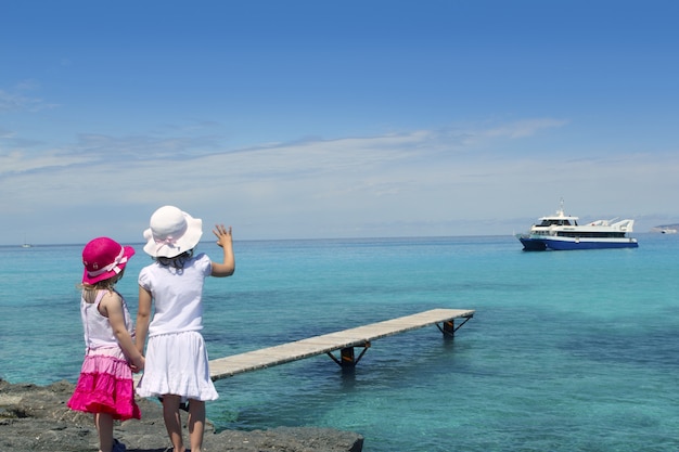 Deux filles touriste mer turquoise au revoir geste de la main