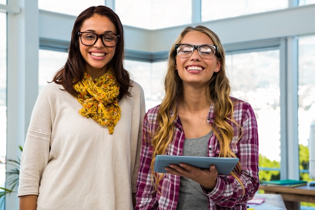 Deux filles travaillent au bureau sur une tablette