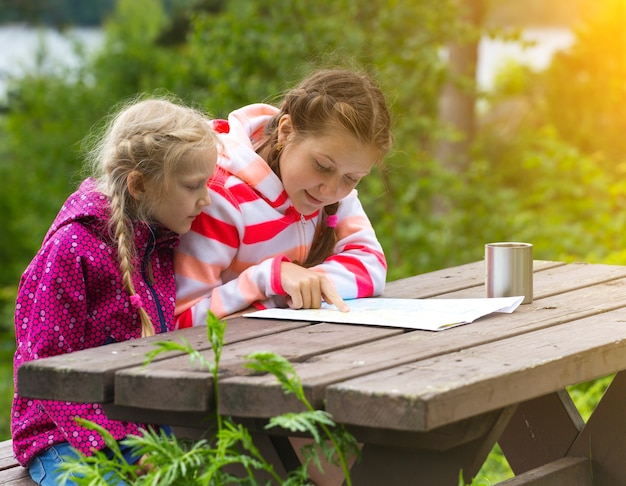 Deux filles voir la carte de s'asseoir sur une table en bois, Norvège