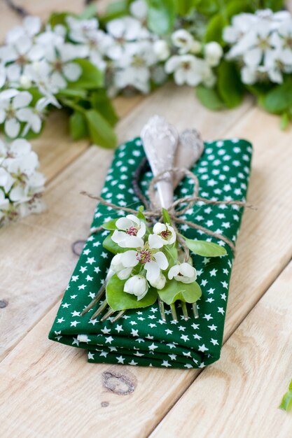 Photo deux fourchettes gisant sur un bois parmi les branches d'un arbre en fleurs