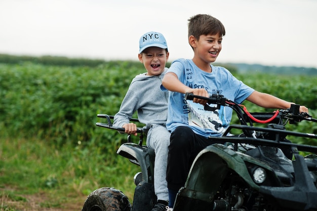 Deux frères au volant d'un quad VTT à quatre roues Moments heureux pour les enfants