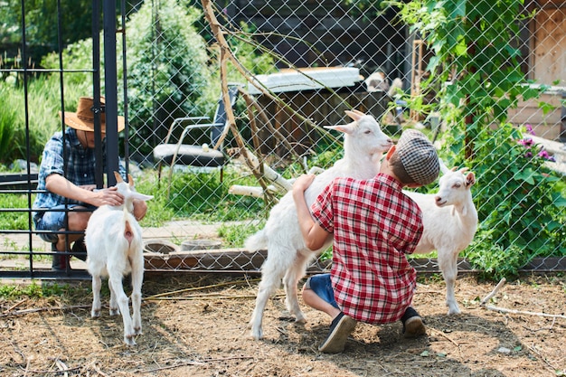 Deux frères dans l'enclos avec les chèvres à la ferme