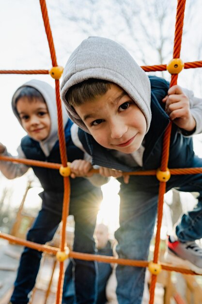 Deux frères garçons mignons jouant sur une aire de jeux en plein air