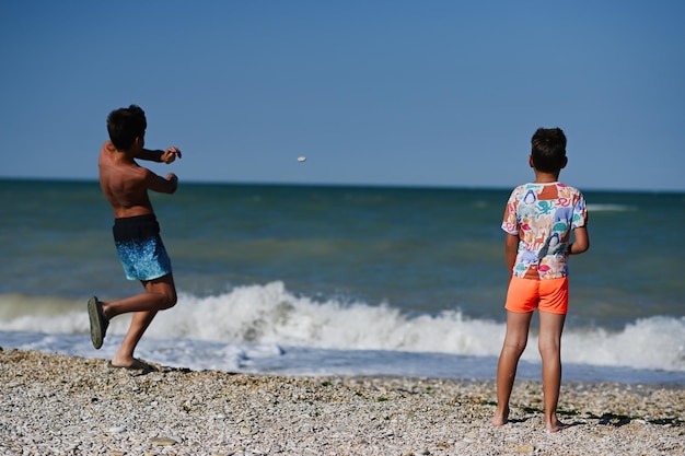 Deux frères jettent des cailloux dans la mer sur la plage Porto Sant Elpidio Italie