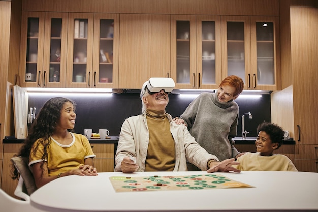 Deux frères et sœurs mignons et leur grand-mère regardant un homme mûr dans un casque vr