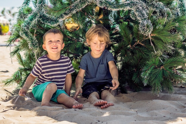 Deux garçons célèbrent Noël sur la plage