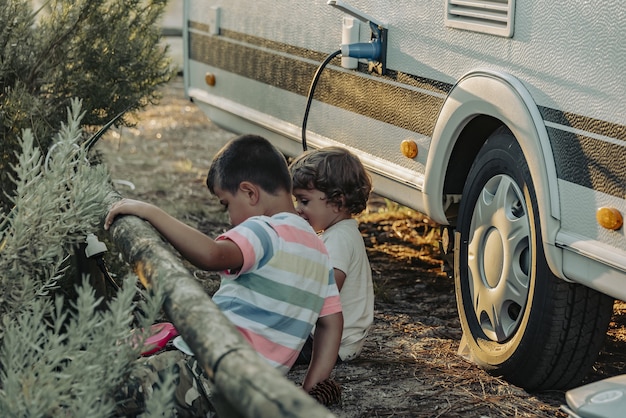 Deux garçons dans une caravane jouant dans la nature