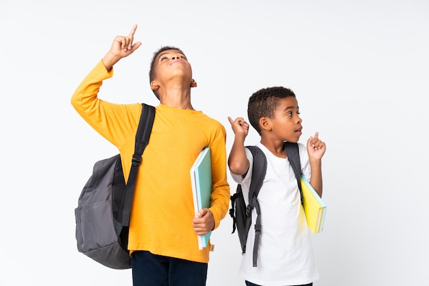 Deux garçons étudiants afro-américainsblanc et pointant vers le haut