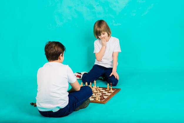 Deux garçons jouant aux échecs, fond de studio, sport