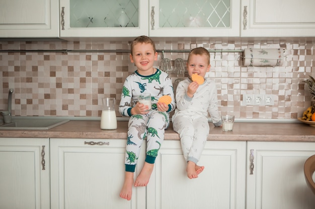 deux garçons prennent leur petit déjeuner dans la cuisine