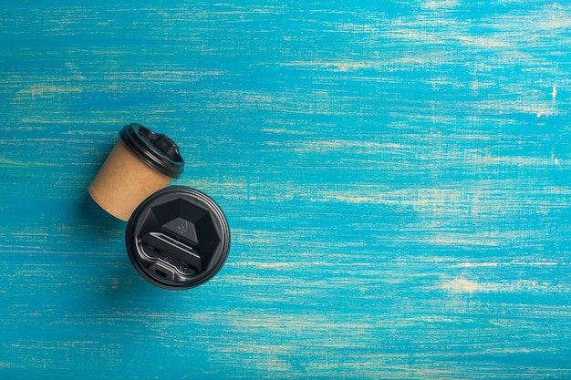 Deux gobelets en papier jetables de différentes tailles de café sur une surface en bois bleue