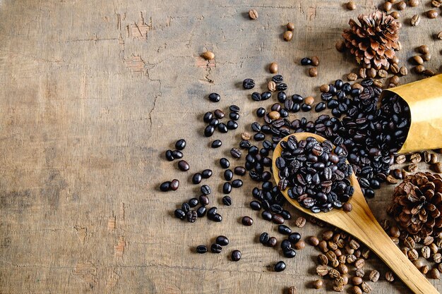 Deux grains de café torréfiés sur une table en bois.