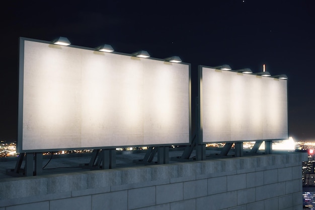 Deux grands panneaux d'affichage vides sur le fond de la ville la nuit se moquent