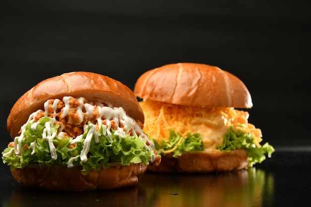 Deux hamburgers avec de la mayonnaise sont assis sur une table.