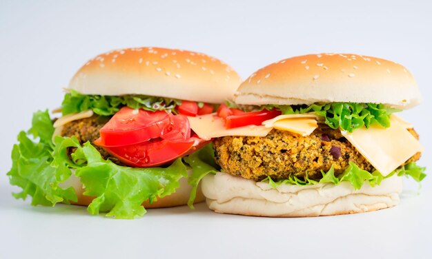 Deux hamburgers végétaliens avec falafel, laitue, tomate et fromage, image isolée sur un fond clair