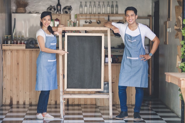 Deux heureux propriétaires de petites entreprises prêts à ouvrir leur café