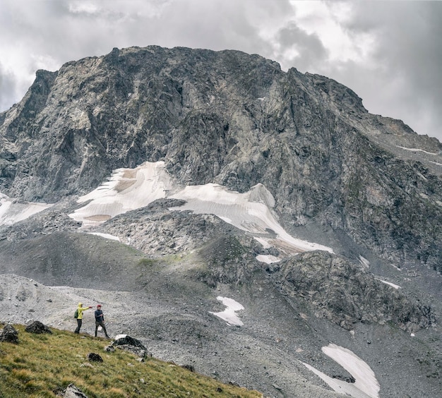 Deux hommes actifs en randonnée sur fond de montagnes rocheuses avec glacier