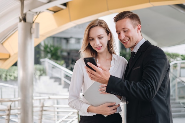 Photo deux hommes d'affaires à l'aide d'une tablette numérique et d'un smartphone ensemble devant le bureau