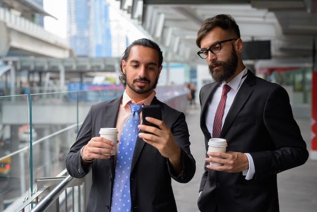 Deux hommes d'affaires barbus ethniques ensemble autour de la ville