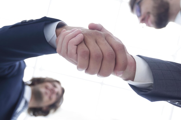 Deux hommes d'affaires confiants se serrant la main lors d'une réunion au bureau succès face à la salutation et au concept de partenaire