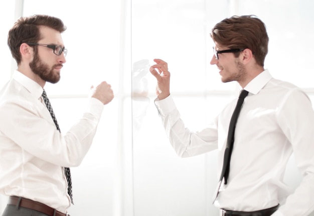 Deux hommes d'affaires debout dans un bureau moderne avec des murs de verre concept d'entreprise