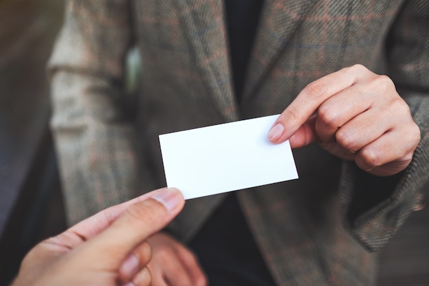 Photo deux hommes d'affaires détenant et échangeant une carte de visite vide