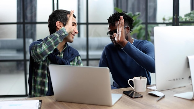 Deux hommes d'affaires donnent un high five au bureau pour se motiver