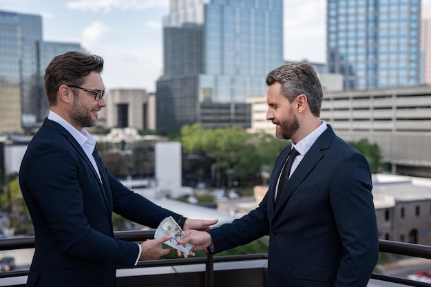 Deux hommes d'affaires de l'équipe commerciale hommes d'affaires donnant de l'argent homme d'affaires offrant de l'argent pour le collage offrant de l'argent