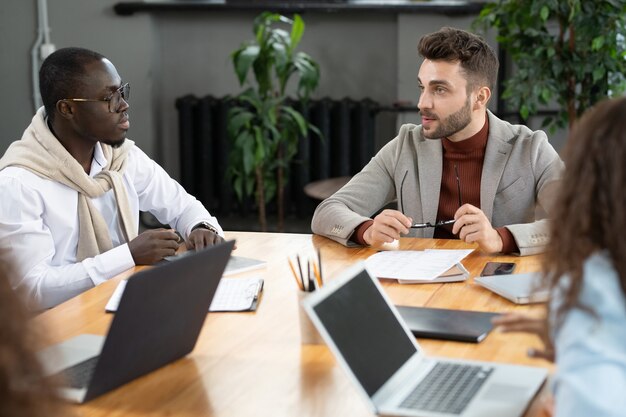 Deux hommes d'affaires interculturels consultant ou remue-méninges lors d'une réunion