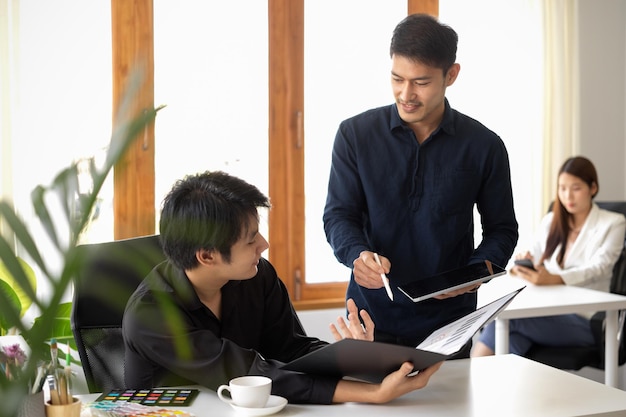 Deux hommes d'affaires parlent et partagent leurs idées pour le projet marketing sur le lieu de travail de bureau