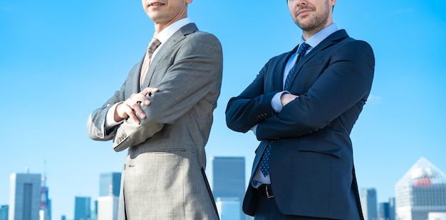 Deux hommes d'affaires posant sous le ciel bleu