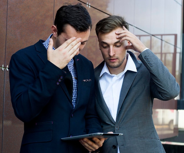 Deux hommes d'affaires regardant la tablette. Échec dans le travail. Les photos peuvent être utilisées pour des présentations d'affaires.