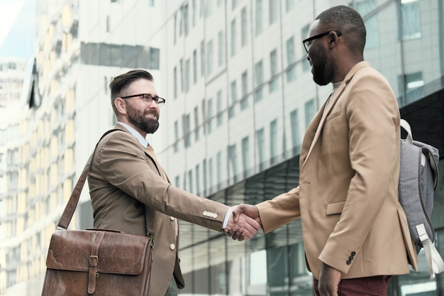 Photo deux hommes d'affaires se serrant la main, ils se saluent lors d'une réunion dans la ville