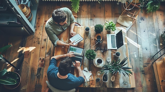 Photo deux hommes d'affaires sont assis à une table en bois dans un bureau rustique ils regardent une tablette et un ordinateur portable